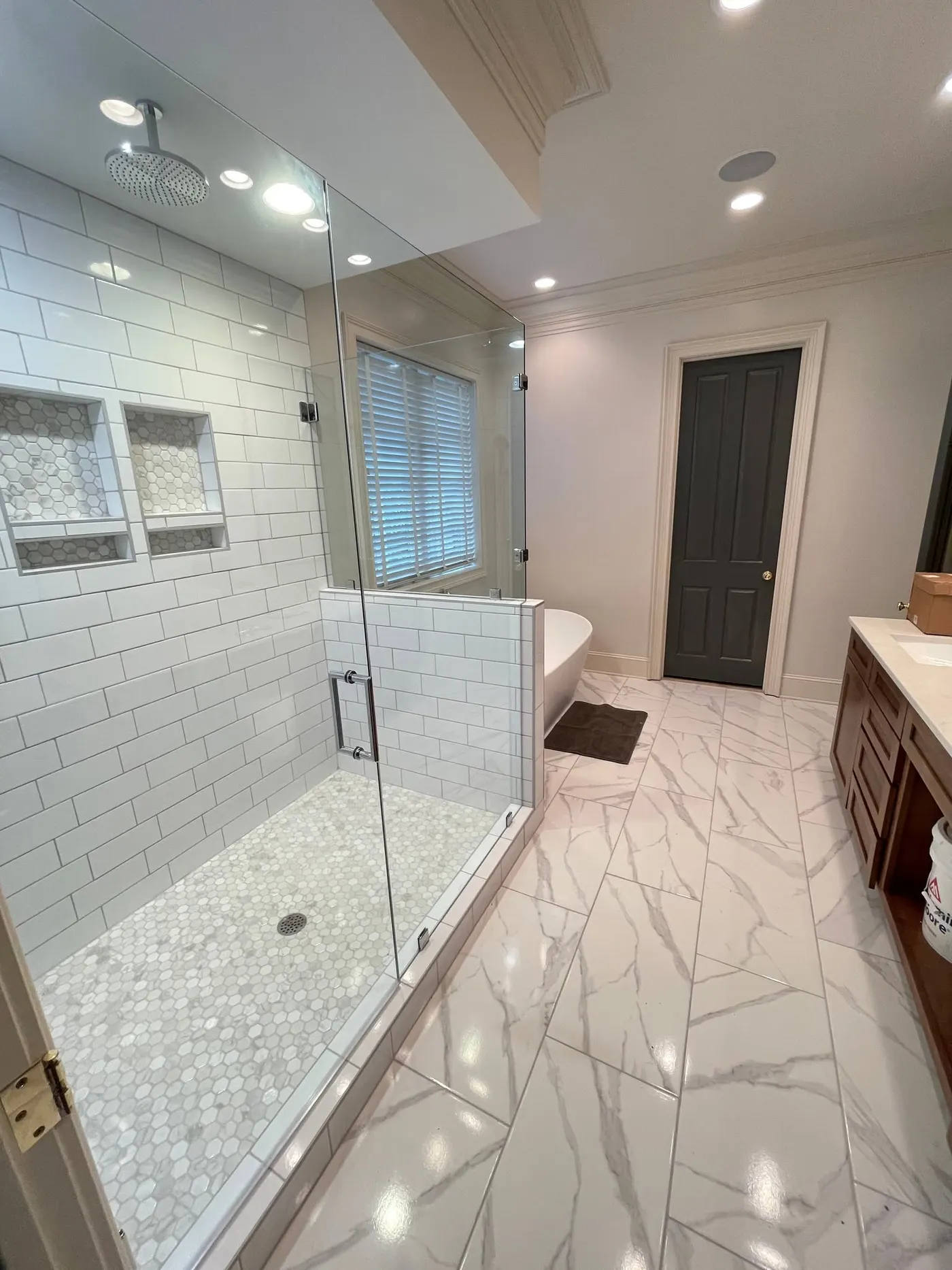 Bathroom remodel with subway-tile shower and marble-look tile