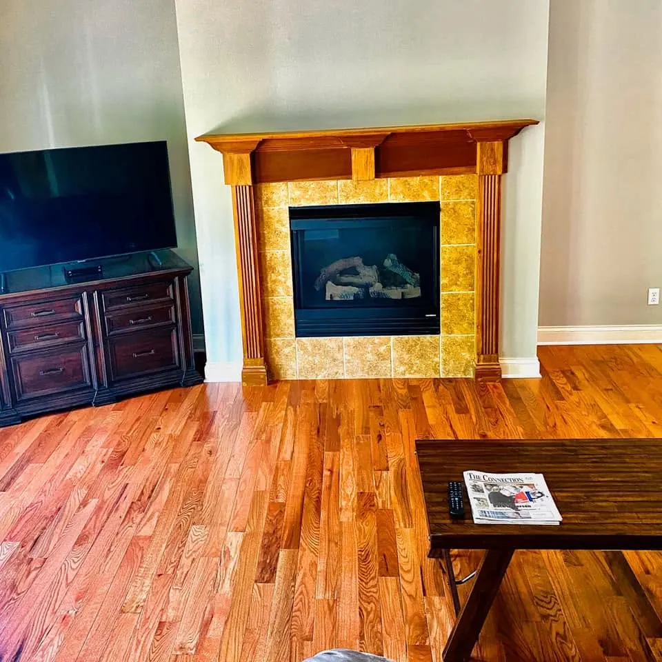 Hardwood living room floor around a tiled fireplace