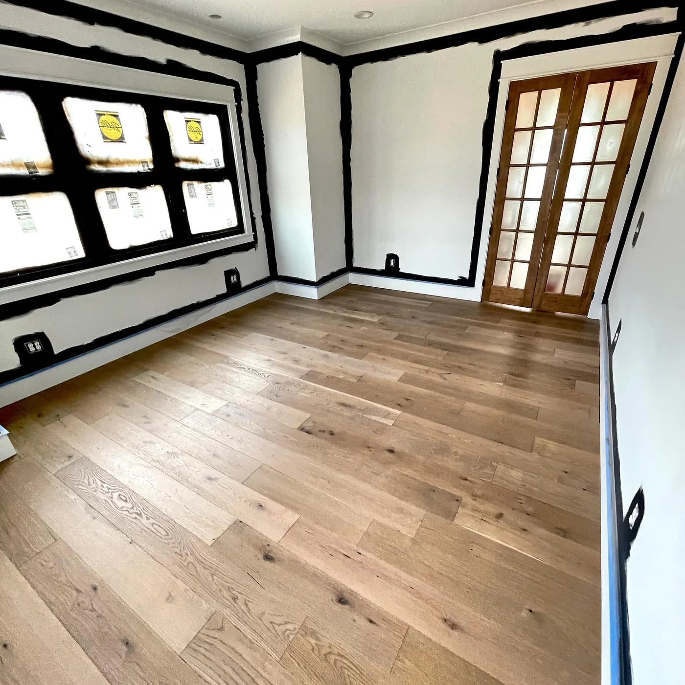 Wide-plank wood flooring in a room with french doors