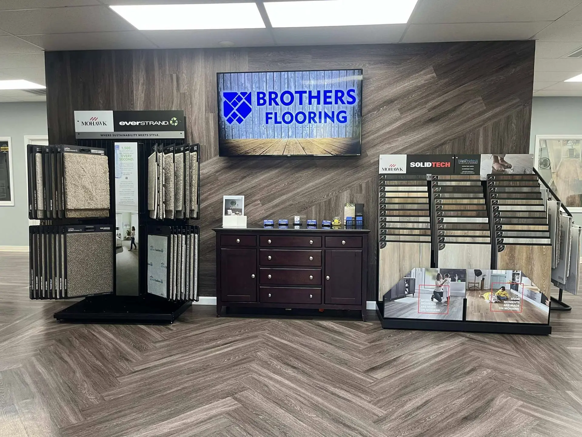 Brothers Flooring showroom with Mohawk EverStrand carpet and SolidTech luxury vinyl displays around the Brothers Flooring sign